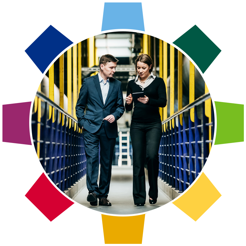 a photo of two facilities managers walking inside a facility and viewing an ipad
